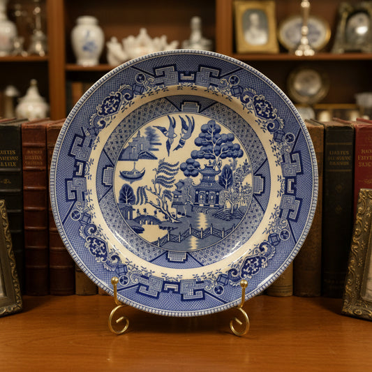 Decorative plate with blue and yellow design on a green fabric background