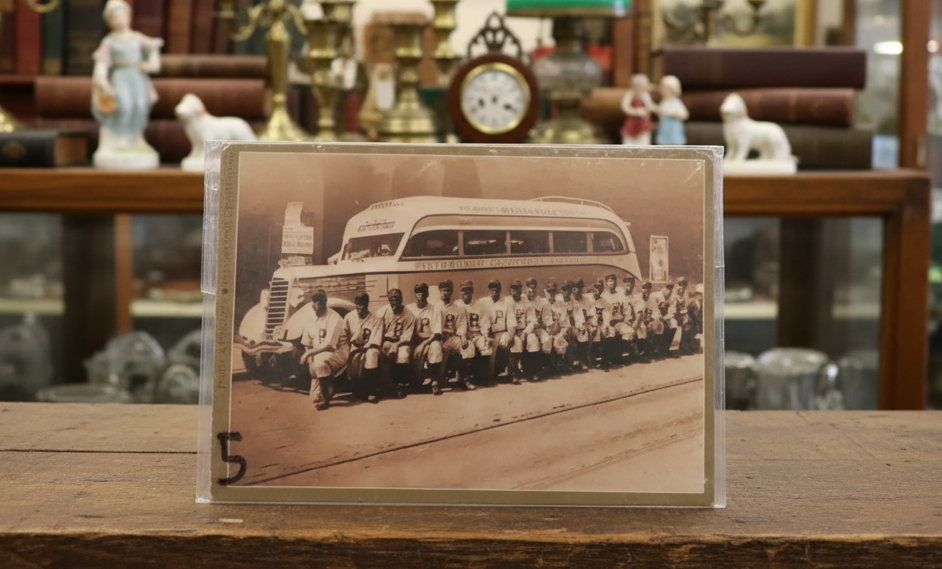 Vintage photograph of a group in front of a bus