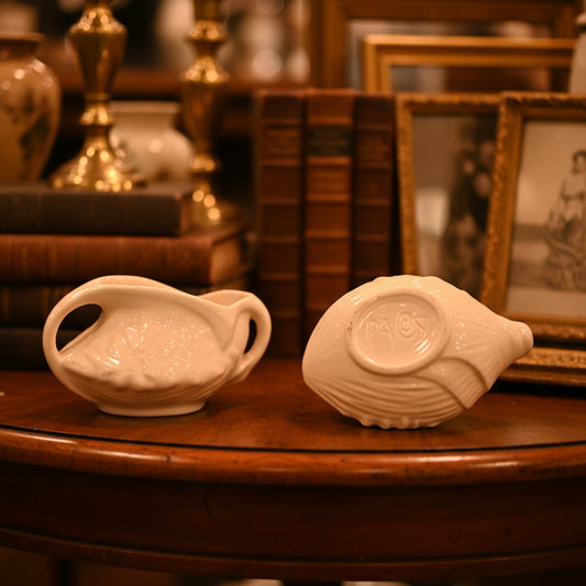 Two white ceramic bowls on a green satin surface